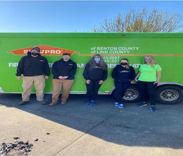 four ladies and on gentleman standing in front of servpro trailer